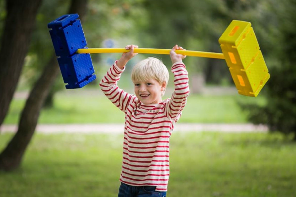 Bambini che utilizzano tappeti, moduli morbidi e percorsi psicomotori in aula scolastica, con materiali adeguati per favorire il movimento in sicurezza.